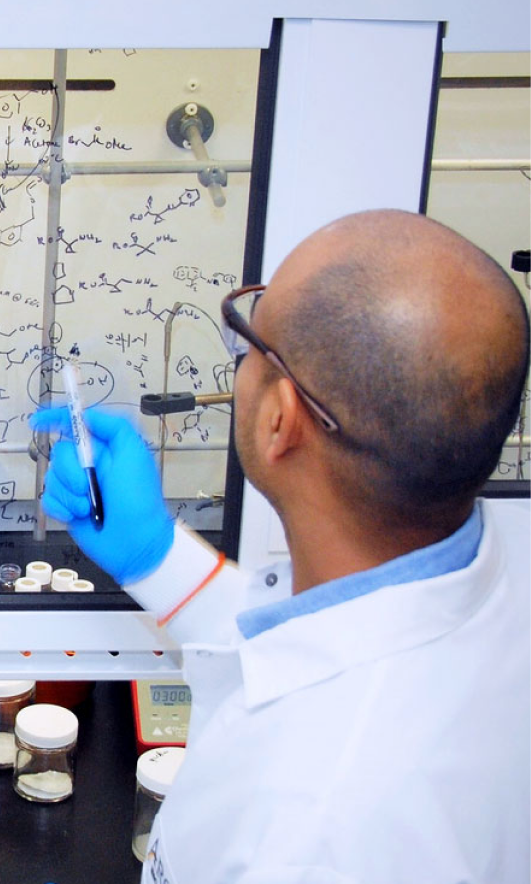 Scientist writing on a glass board